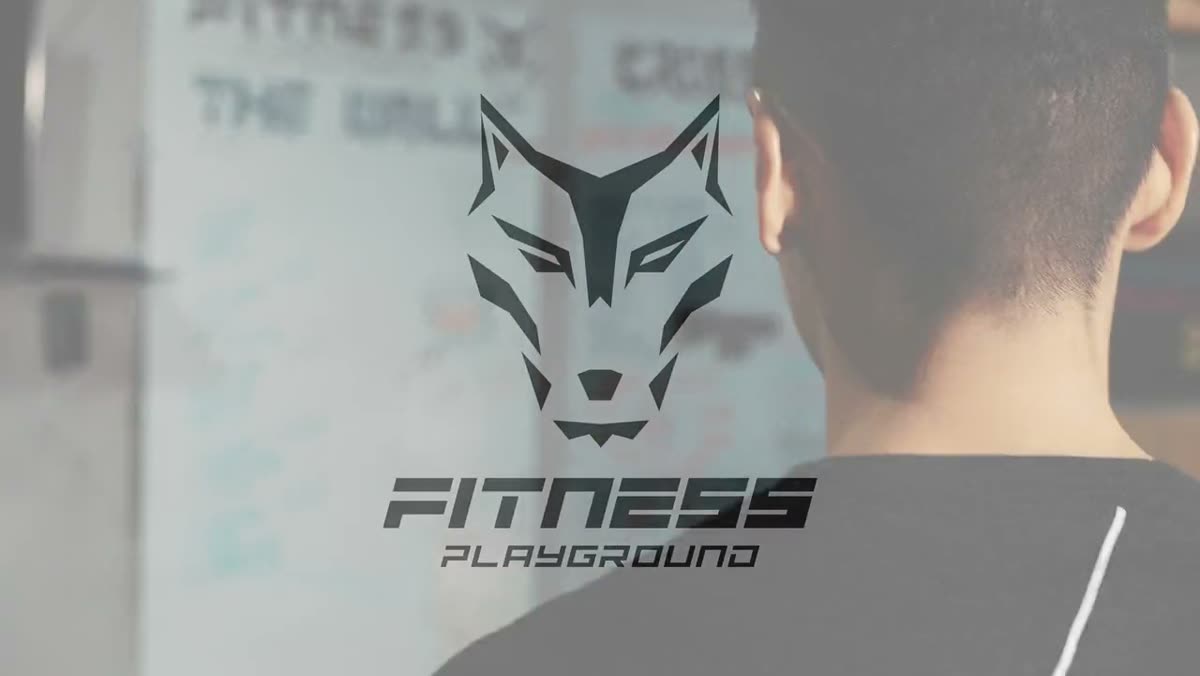 The Fitness Playground wolf mark on a gym whiteboard, a member in front of it.