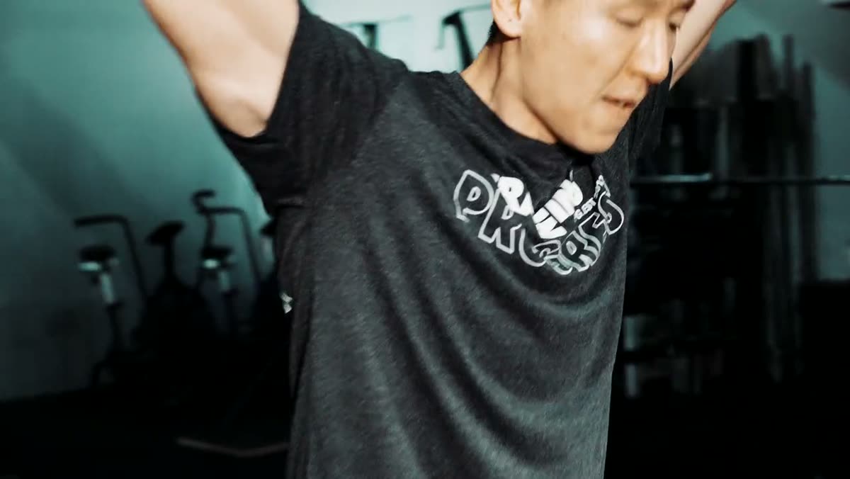 A gym member stretching and catching their breath mid-session.