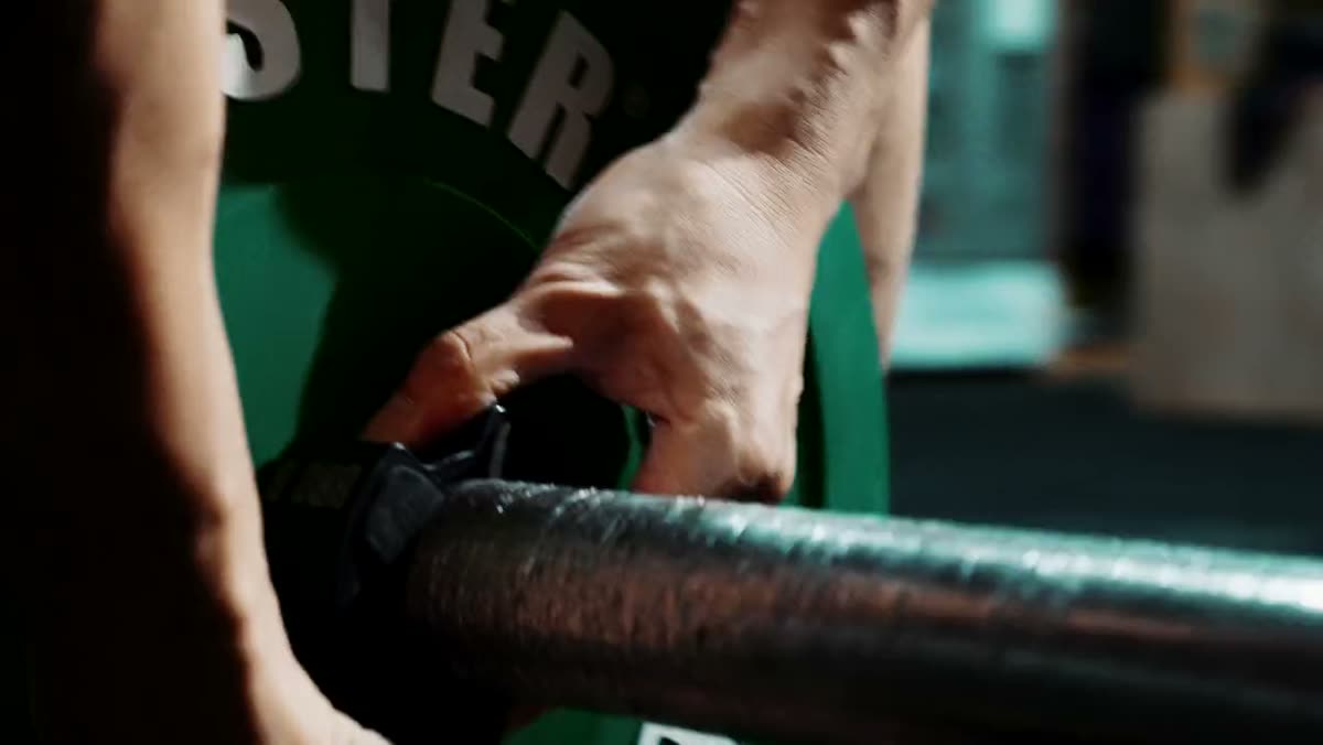 Hands clipping a collar onto a loaded barbell.