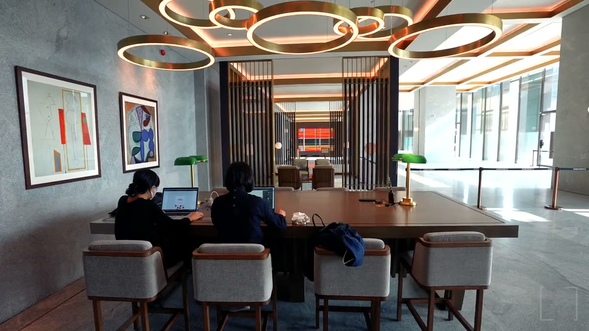 People working at a long table in a meeting room.