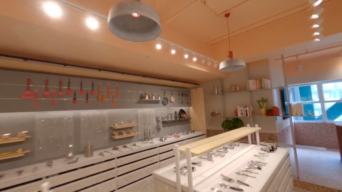 A wide view of the showroom under pendant lighting.