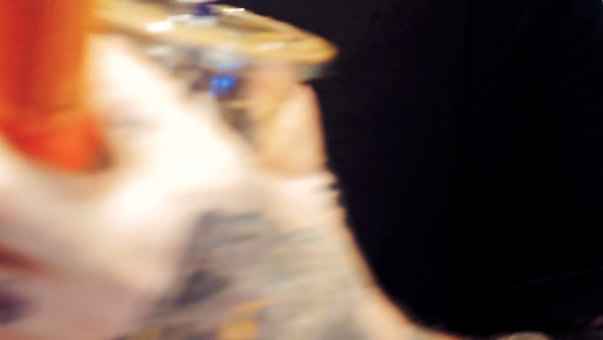 A close, shallow-focus shot of a tattoo machine and ink caps.