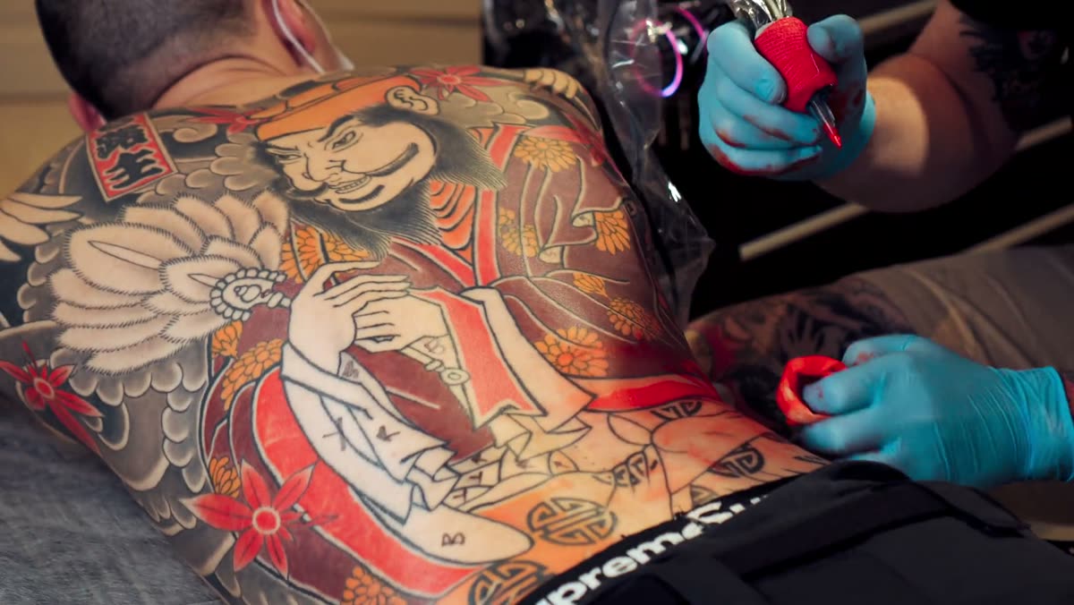 A completed Japanese-style back tattoo being worked on.