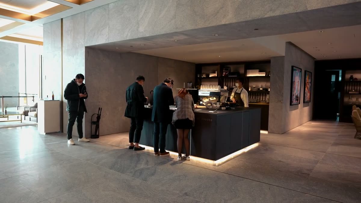 A wide view of the cafe counter with customers being served.