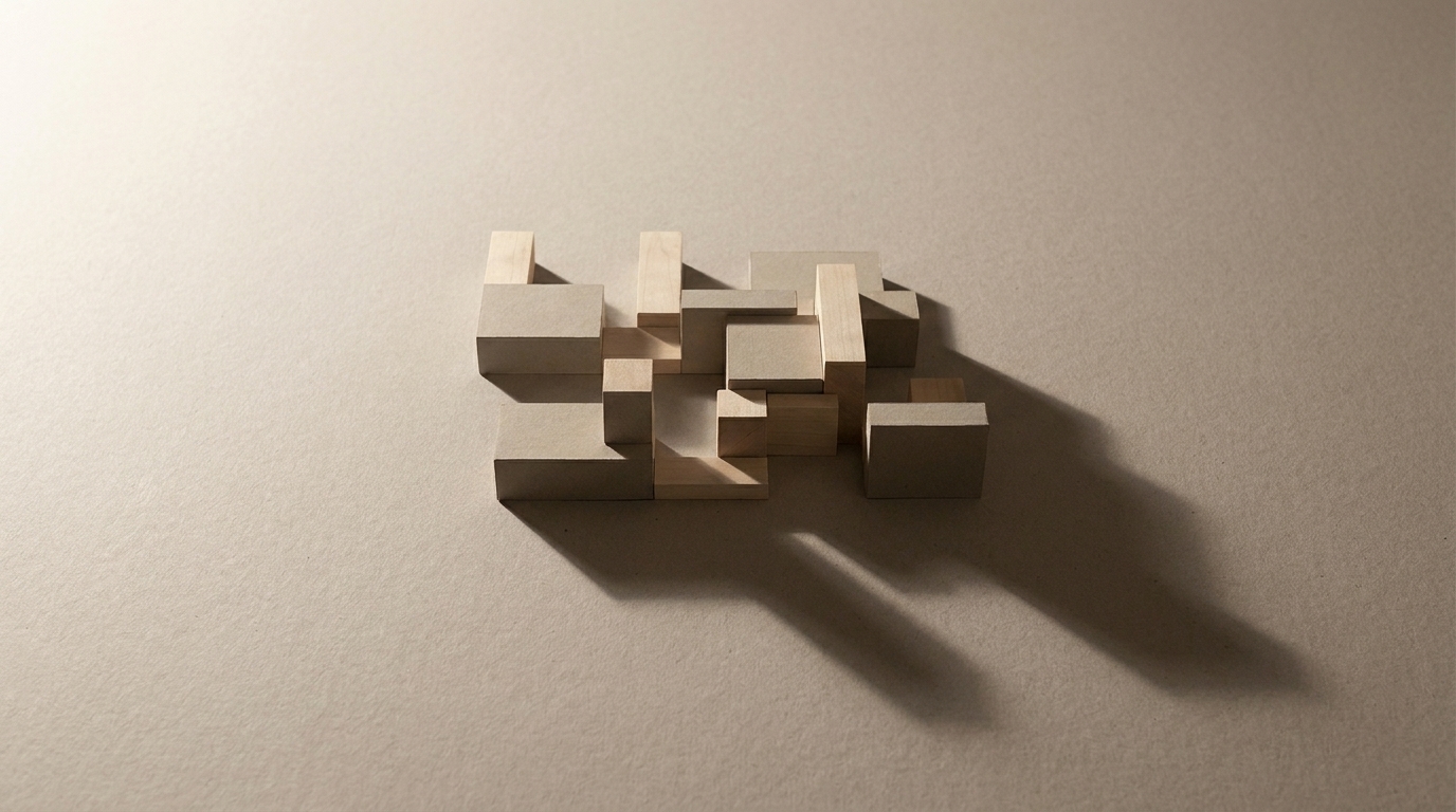 A single massing model alone on a large bare board, one long shadow reaching across the empty surface.