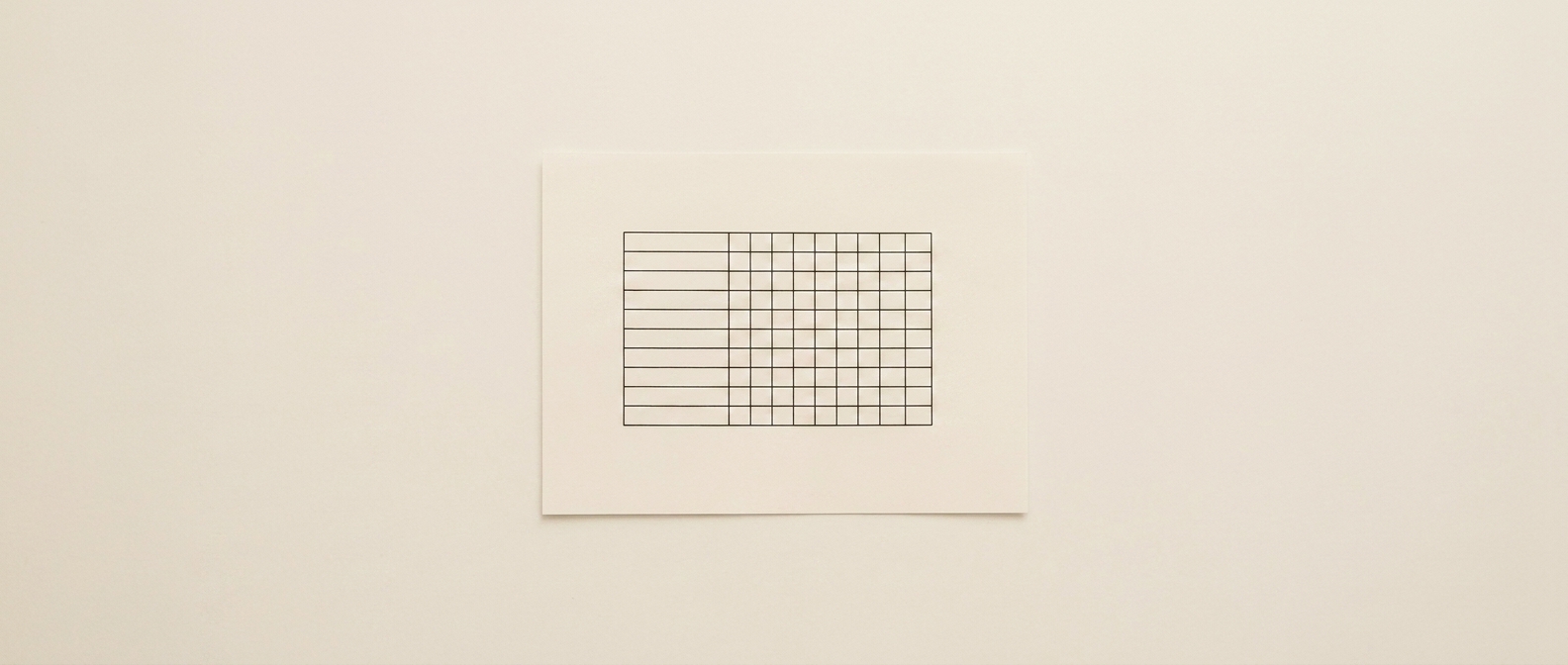 A single sheet alone on a plain pale surface, carrying one blank ruled matrix, with generous empty space around it.