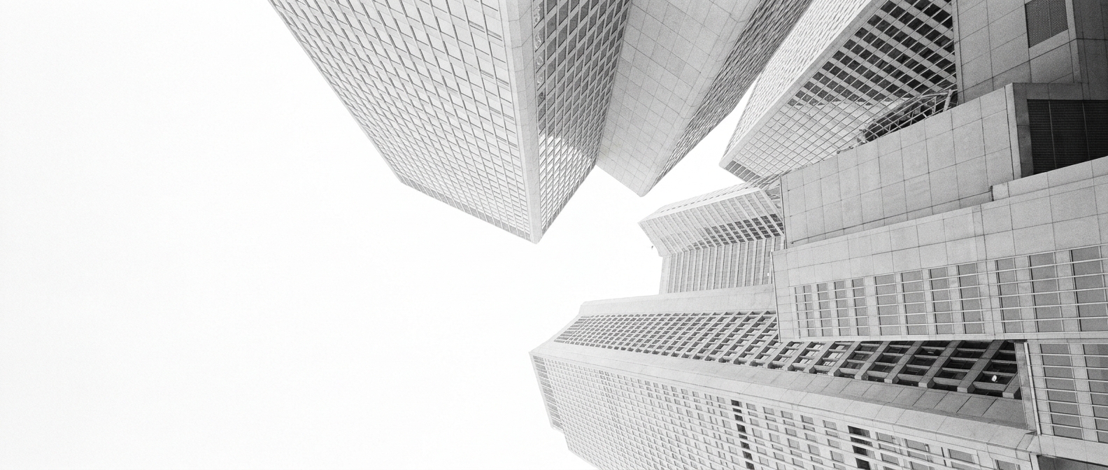 Office towers seen from below against a white sky.